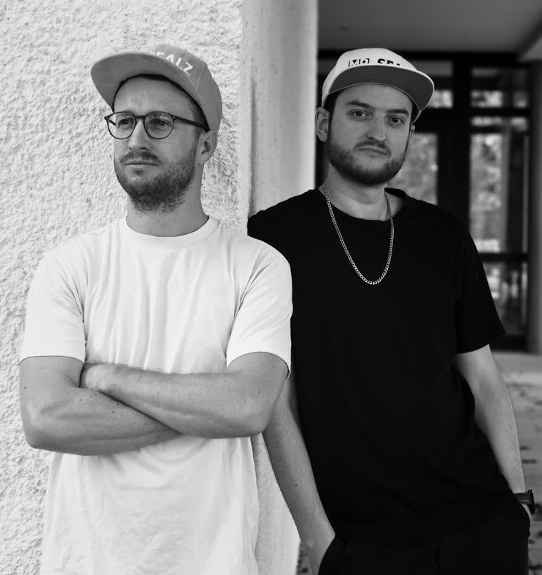 Dave und Flo vor einer weißen Wand, beide mit Mr.-Sealz-Cap.